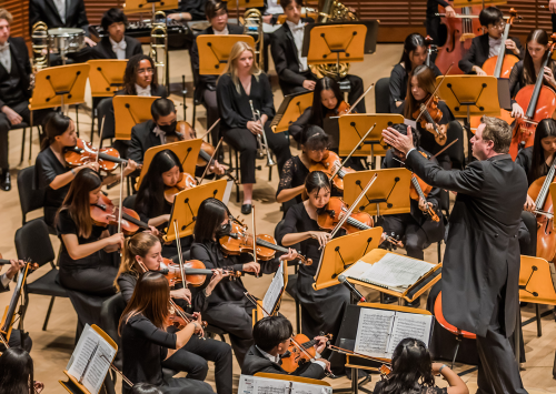 Man conducting orchestra from podium