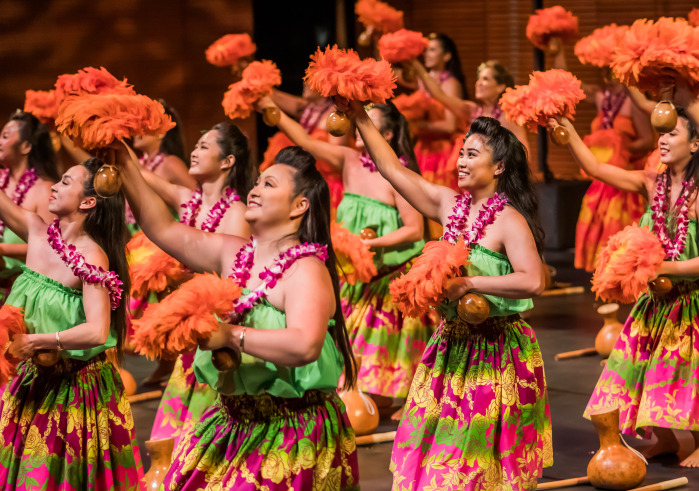 Hawaiian Dancers on stage in orange and green costumes
