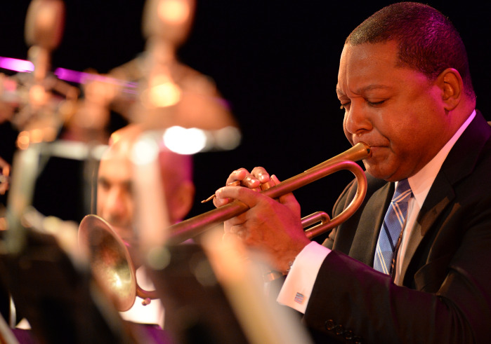 Man in blue suite playing a trombone