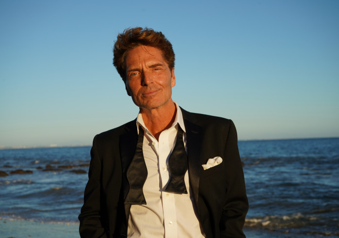 Man standing by the ocean in a suit